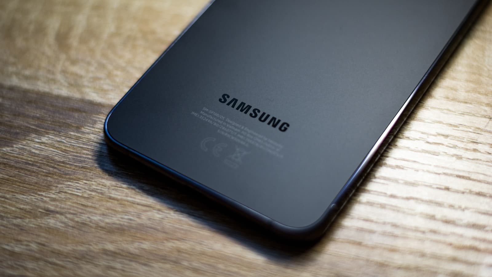 Samsung Galaxy A54 5G in Awesome Graphite, shown on a dark editorial backdrop
