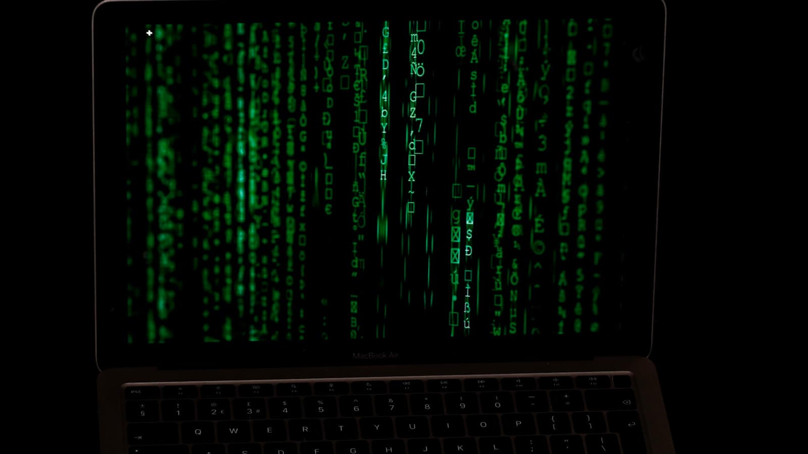 Laptop displaying green terminal-style code, representing malicious open-source package security risks