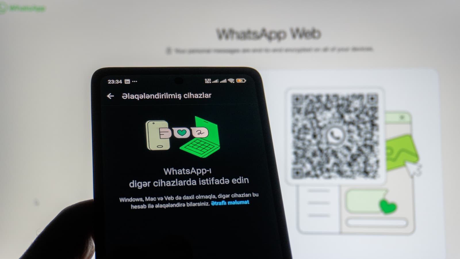 Phone scanning a WhatsApp Web QR code, representing social media scam and account takeover risks